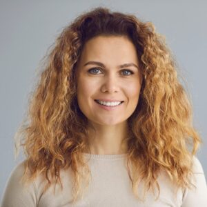Happy woman with long wavy golden brown hair, perfect white smile.