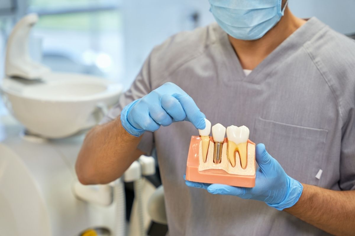 skillful-dental-technician-showing-anatomy-of-dental implant skillful-dental-technician-showing-anatomy-of-dental implant